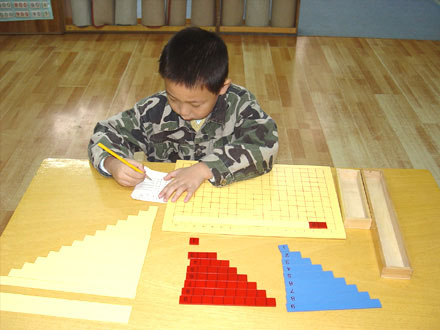 孩子在认真地进行蒙氏计算